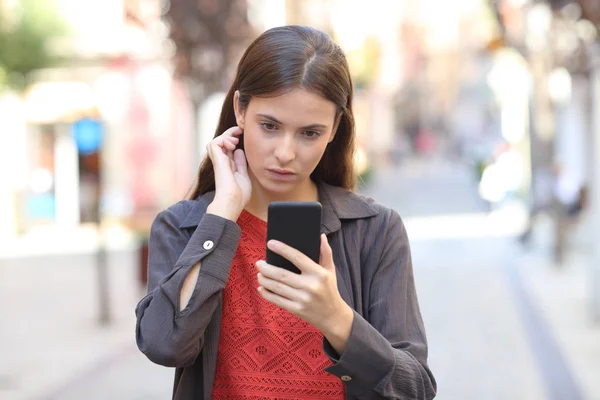 Serieus meisje met behulp van mobiele telefoon aanraken van haar — Stockfoto