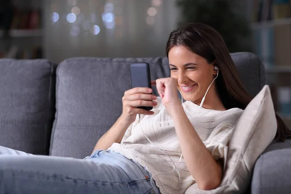 Szczęśliwa nastolatka kłamie słuchając muzyki przez telefon — Zdjęcie stockowe