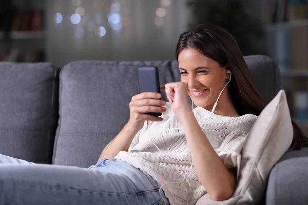 Heureuse adolescente couchée écoutant de la musique au téléphone — Photo