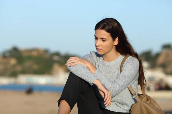 Melancholic pensive girl looking down on the beach — Stock Photo, Image