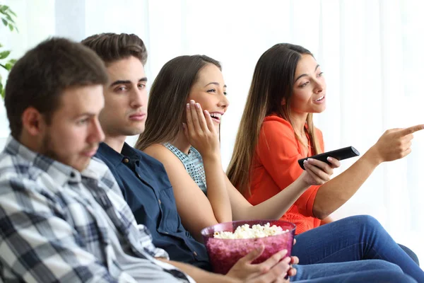 Girls watching romantic movie with their bored boyfriends — Stock Photo, Image