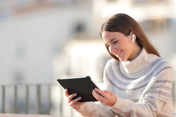 Mujer feliz viendo los medios de comunicación en la tableta en un balcón — Foto de Stock