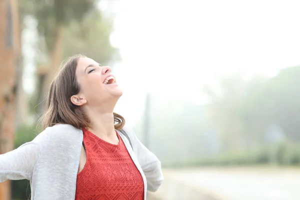 Glückliche Frau atmet an einem nebligen Tag frische Luft — Stockfoto