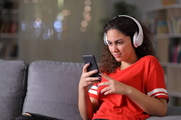 Дівчина в червоному прослуховуванні музики вдома — стокове фото