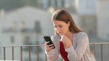 Cep telefonu içeriğini kontrol eden heyecanlı kadın balkonda başarıyı kutluyor 