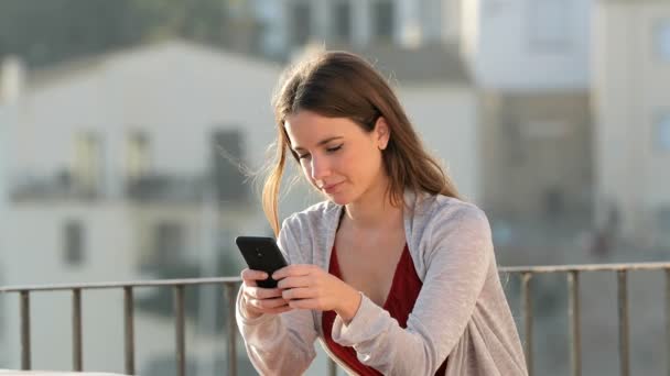 Verrassende Vrouw Die Mobiele Telefoon Een Balkon Een Landelijke Stad — Stockvideo
