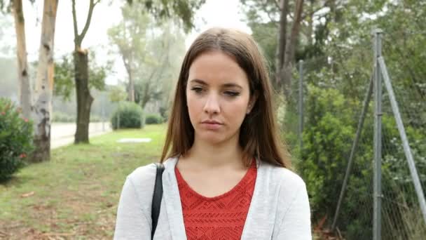 公園を一人で歩く一人の悲しい女性のフロントビューの肖像画 — ストック動画