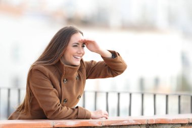 Balkondan ileriye bakan mutlu kadın