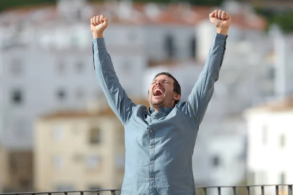 Emocionado hombre celebrando buenas noticias levantando armas — Foto de Stock