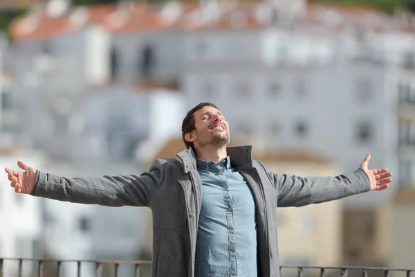 Homem feliz celebrando o novo dia esticando os braços no inverno — Fotografia de Stock