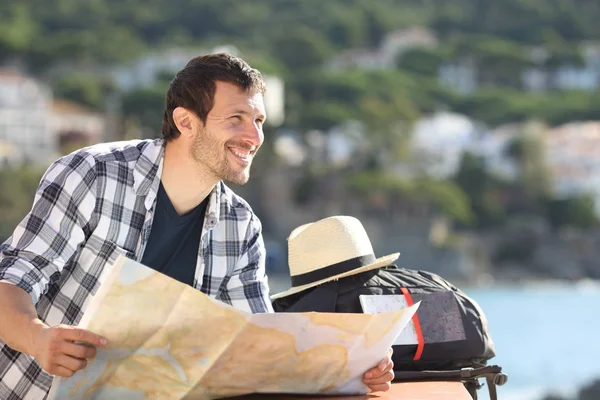 Feliz turista sosteniendo el mapa contemplando vistas de vacaciones — Foto de Stock
