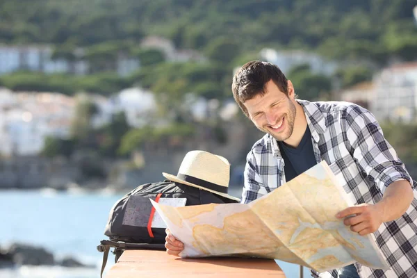 Felice controllo turistico mappa in viaggio in una città costiera — Foto Stock