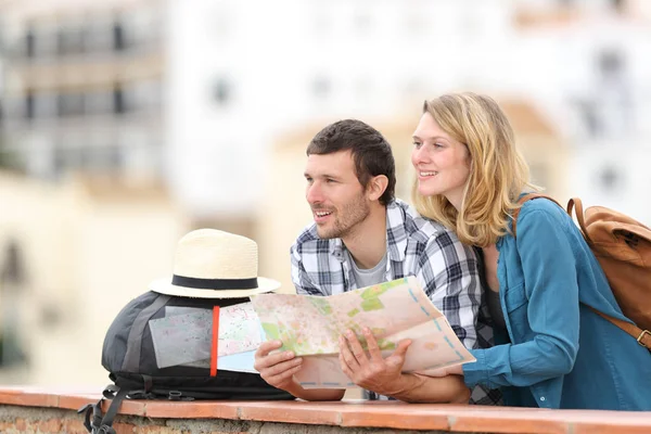 Gelukkige paar toeristen sightseeing holding kaart — Stockfoto