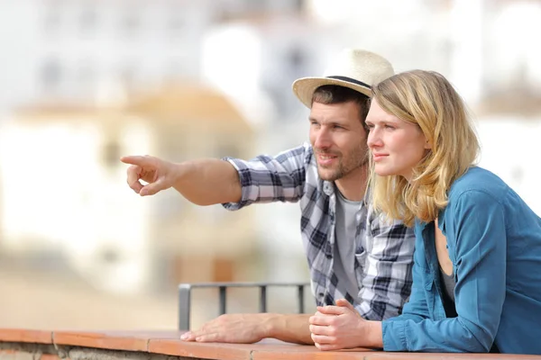 Пара туристов осматривают достопримечательности, указывая на горизонт — стоковое фото