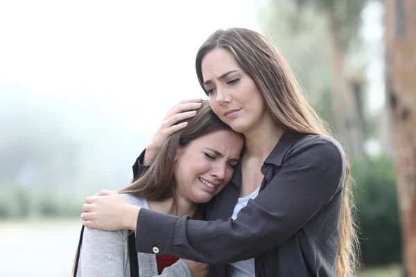 Droevige vrouw huilen en een vriend troosten haar — Stockfoto