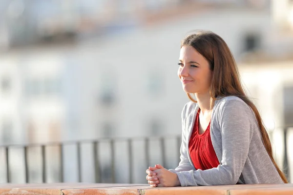 Розслаблена жінка розмірковує над видами з балкона — стокове фото