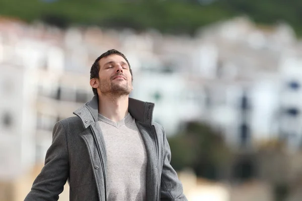 Hombre adulto respira profundamente aire fresco en una ciudad rural en invierno — Foto de Stock