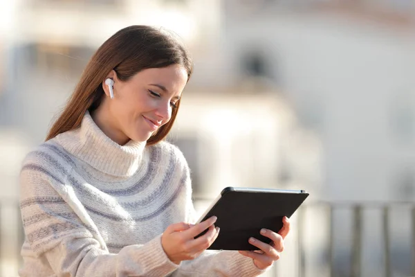 Mulher satisfeita e-learning usando tablet em uma varanda — Fotografia de Stock