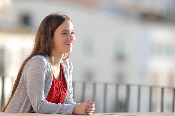 Gelukkige vrouw overweegt uitzicht op een balkon — Stockfoto