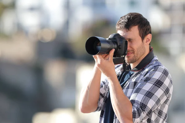Ο άνθρωπος τραβάει φωτογραφίες με μια κάμερα dslr σε μια πόλη — Φωτογραφία Αρχείου
