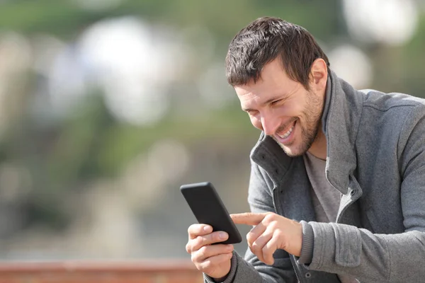 Šťastný dospělý muž pomocí chytrého telefonu v zimě venku — Stock fotografie