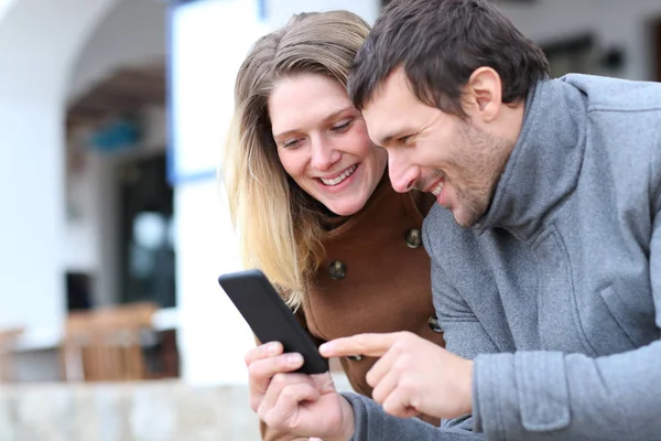 Glada par vuxna checkar smarttelefon på vintern — Stockfoto