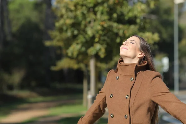 Satisfied woman breathing fresh air in a park — Stock Photo, Image
