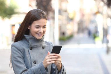 Kışın cep telefonu kullanan mutlu bir kız.