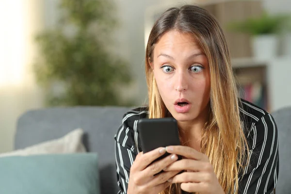 Überraschte Frau findet erstaunliche Inhalte am Telefon — Stockfoto