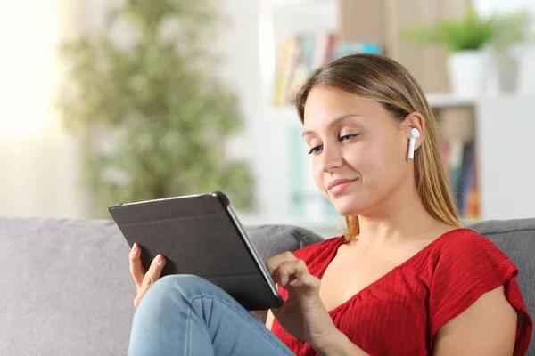 Wanita belajar menggunakan tablet dan earphone di rumah — Stok Foto