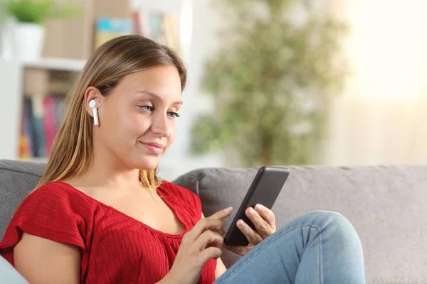 Dame hört Musik mit Telefon und drahtlosen Ohrhörern — Stockfoto