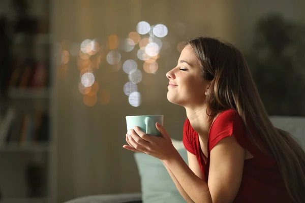 Расслабленная женщина пьет кофе по ночам дома — стоковое фото