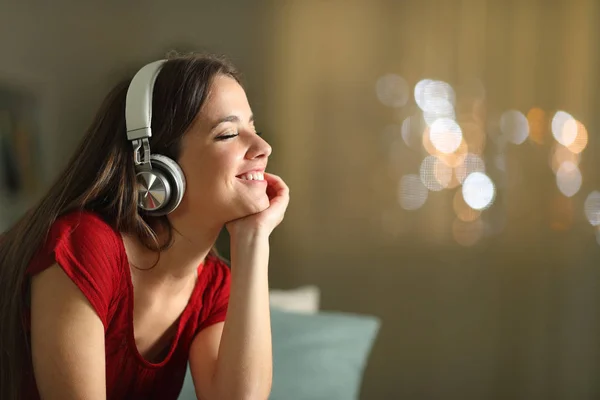 Happy woman listening to music at home in the night — Stock Photo, Image