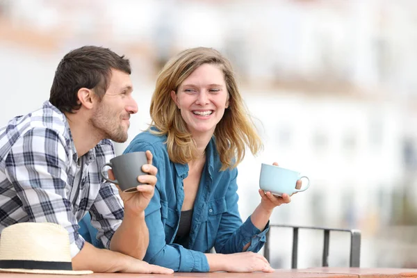 Pareja feliz hablando tomando café en un balcón —  Fotos de Stock