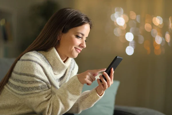 Жінка використовує мобільний телефон вночі вдома взимку — стокове фото