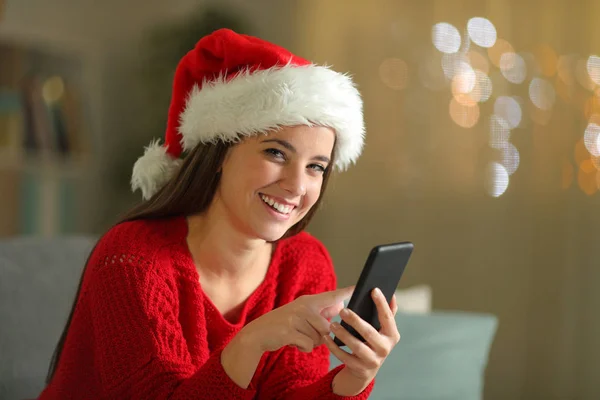 Happy woman holding phone in christmas at home — Stock Photo, Image
