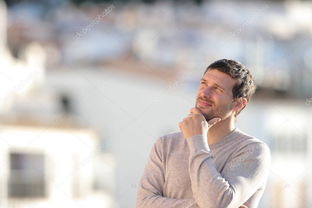 Pensive serious man looking sideways in a town