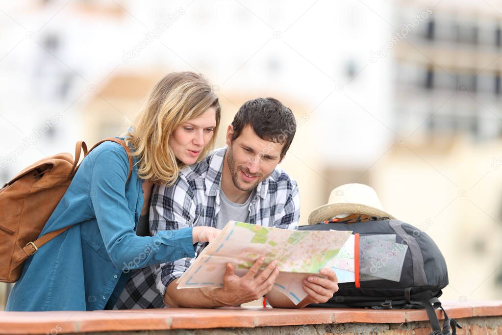 Couple of tourists talking checking map on vacation