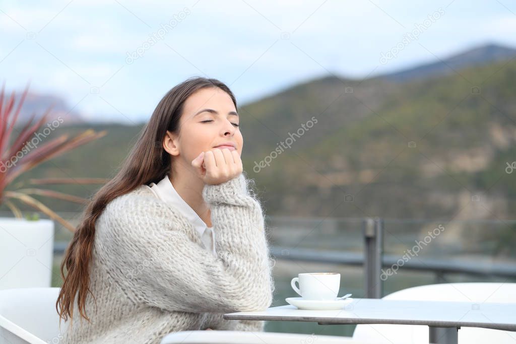 Satisfied woman in a coffee shop breathing fresh air