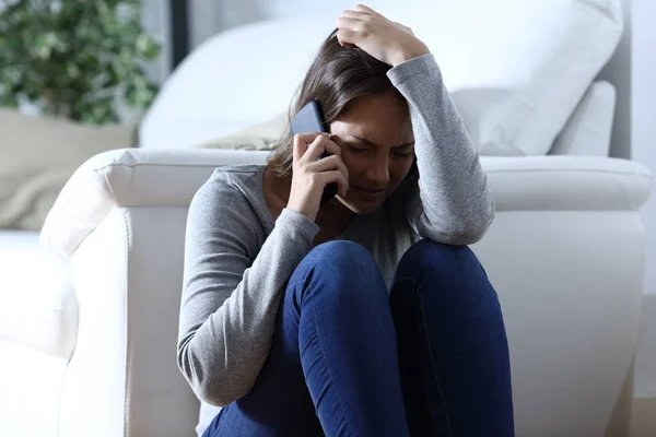 Сумна жінка скаржиться говорити по телефону вдома — стокове фото