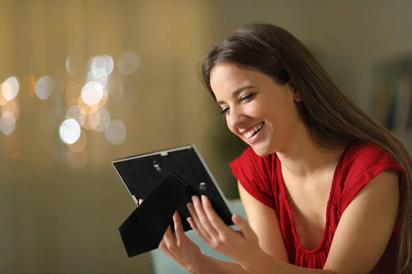 Mujer feliz recordando buenos momentos mirando el marco de la imagen — Foto de Stock