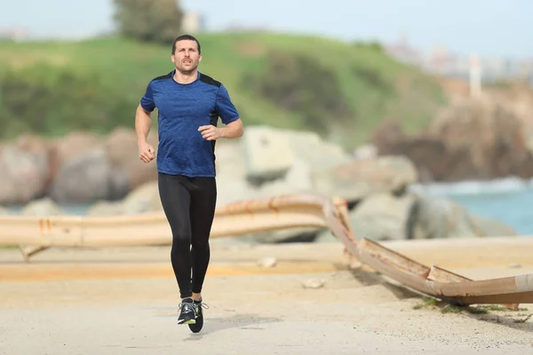Ernsthafter Läufer läuft am Strand — Stockfoto