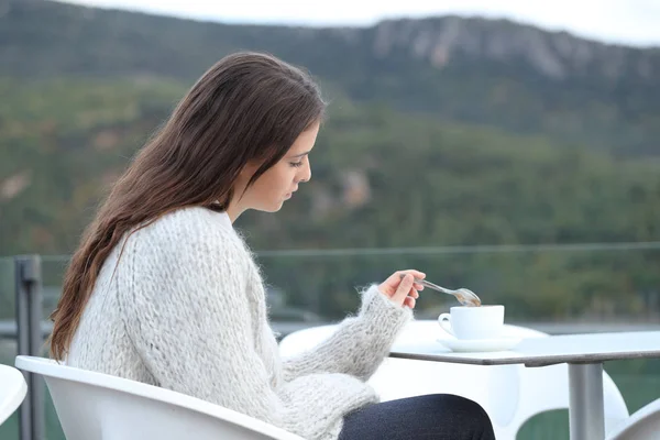 Triste adolescente mescolando caffè in una terrazza ristorante — Foto Stock