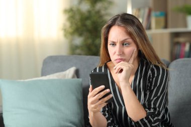 Karışık kadın cep telefonu içeriğini evde kontrol ediyor