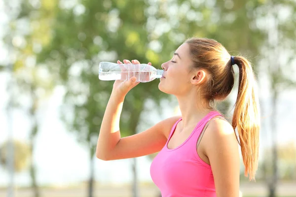 Profile of a runner hidrating drinking bottled water — Stock Photo, Image