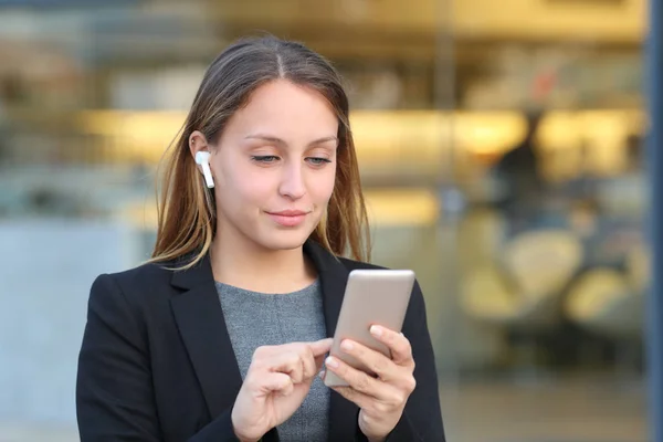 Manager trägt Ohrhörer mit Handy auf der Straße — Stockfoto