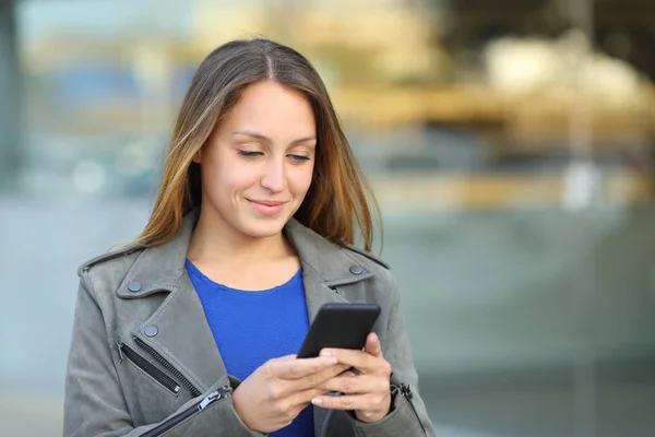 Mulher usando celular caminha na rua — Fotografia de Stock