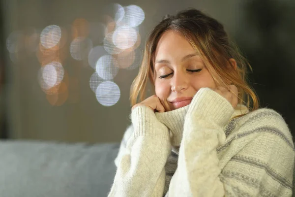 Задоволена жінка тепло одягнена вдома вночі — стокове фото