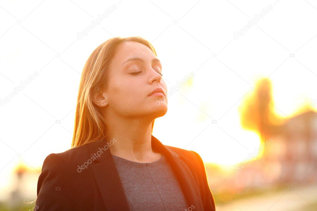 Businesswoman breathing fresh air at sunset outdoors
