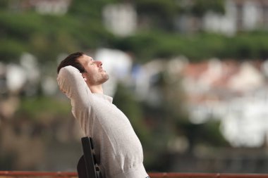 Dışarıdaki bankta oturan rahat bir adamın profili.